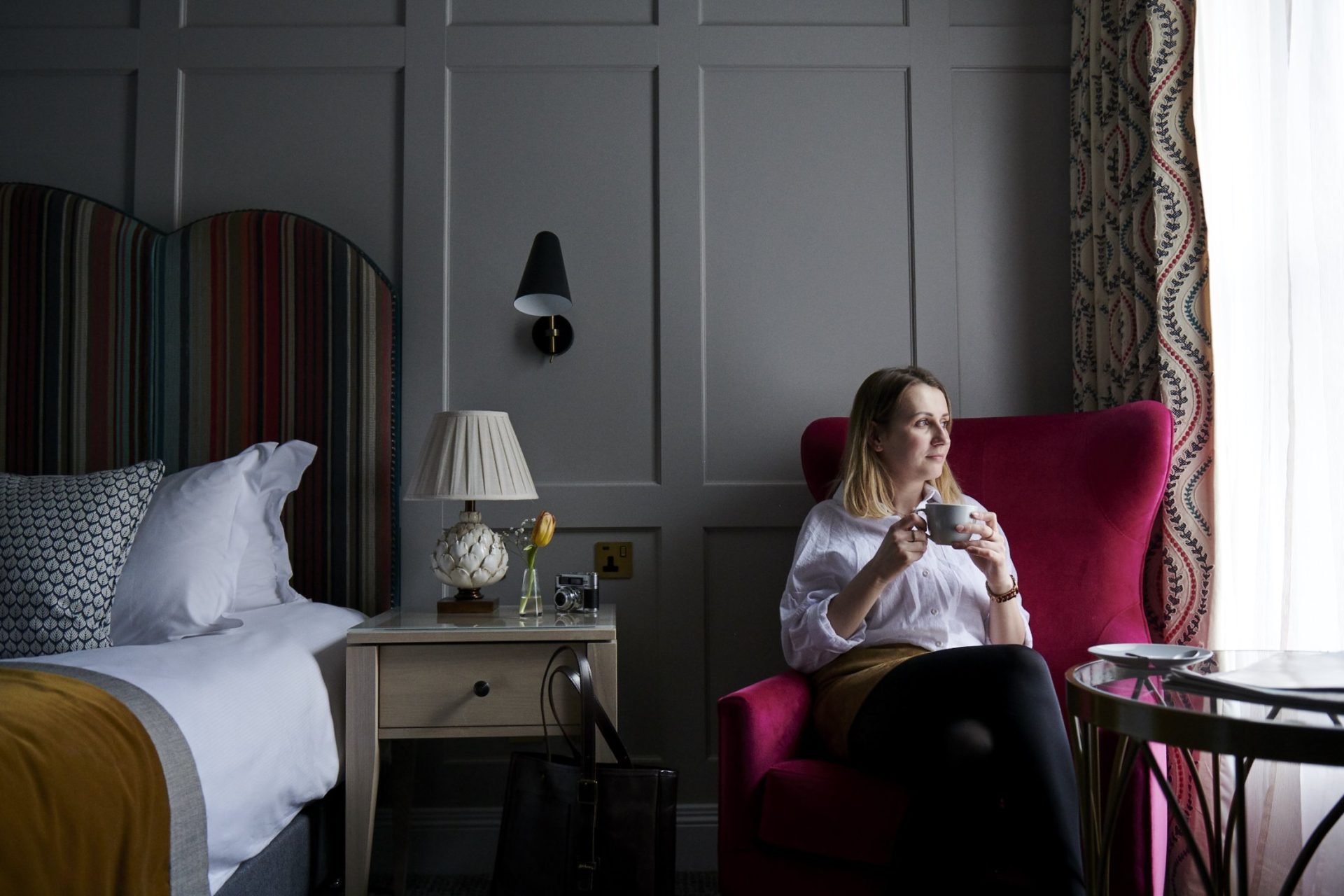 woman drinking coffee in hotel room