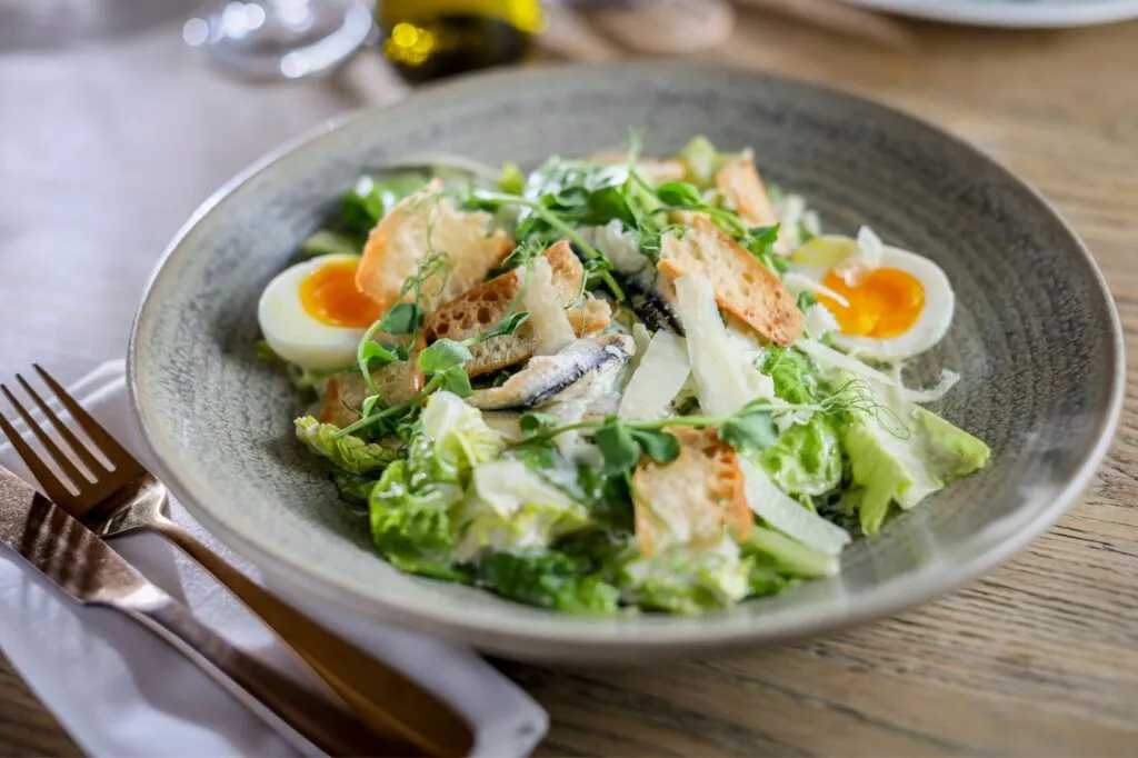 The Francis Hotel Bath classic Casear salad, parmesan, croutons, anchovies, soft boiled egg, Caesar dressing close up